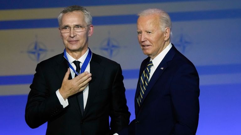 President Joe Biden, right, presents NATO Secretary General Jens Stoltenberg...