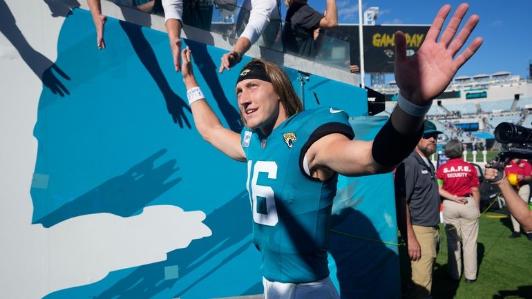 Jacksonville Jaguars quarterback Trevor Lawrence (16) waves to fans as...