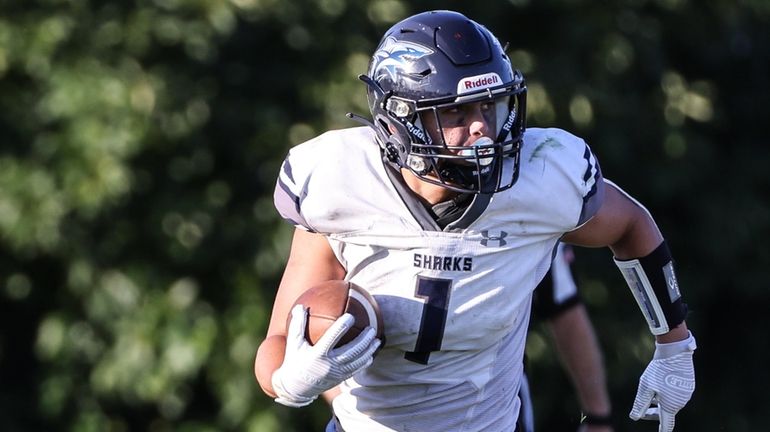 Eastport-South Manor's Daniel Odell sweeps to the right side of...