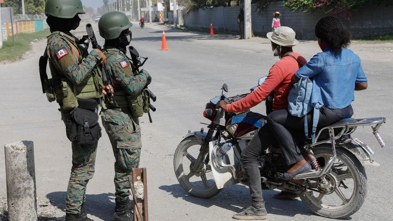 Soldiers patrol the road near the international airport in Port-au-Prince,...