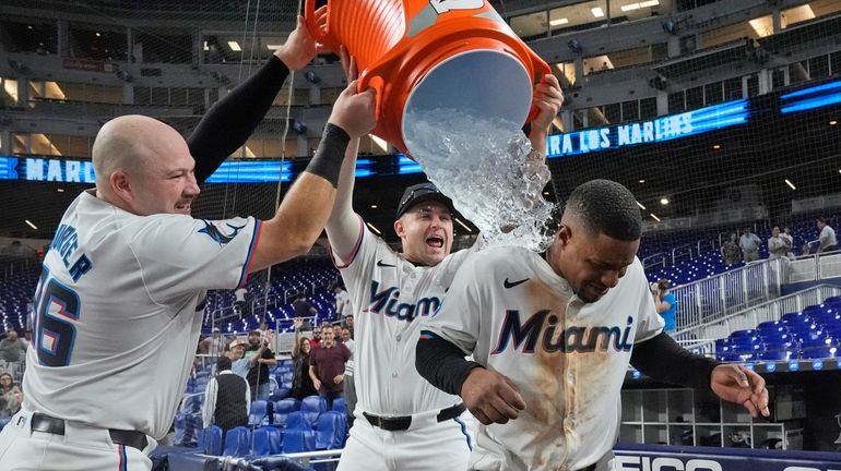 Miami Marlins first baseman Jake Burger, left, and designated hitter...