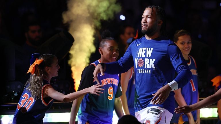 Jalen Brunson #11 of the New York Knicks walks on...