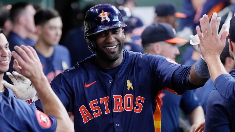 Houston Astros' Yordan Alvarez is congratulated in the dugout after...