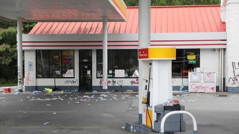 Debris is spread out in front of a convenience store,...