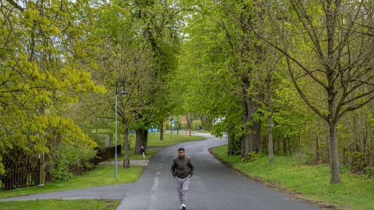 Kuche Khan, a 47-year- old asylum seeker, walks towards the...