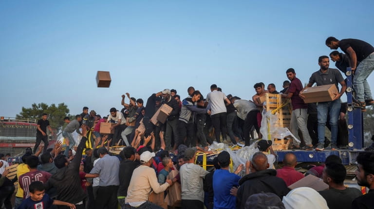 Palestinians are storming trucks loaded with humanitarian aid brought in...