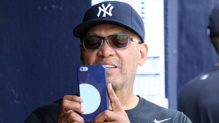 Reggie Jackson takes photos in the dugout during the game...