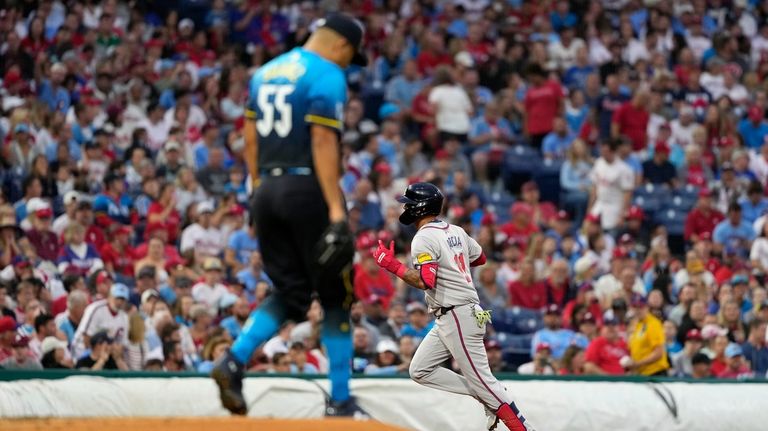 Atlanta Braves' Orlando Arcia, right, reacts after hitting a home...