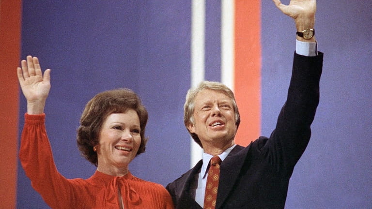 Jimmy Carter, right, and his wife, Rosalynn Carter, wave together...