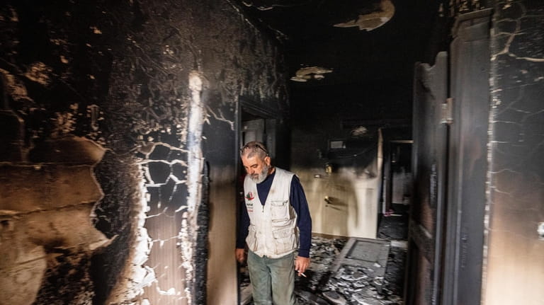 Hussein Salman inspects damages to his family house that was...