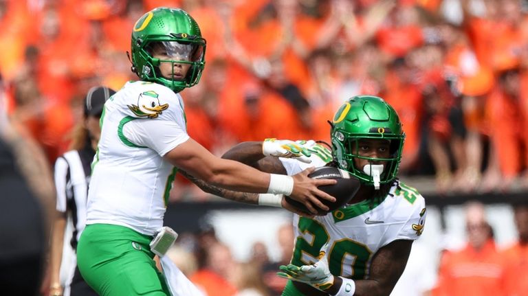 Oregon quarterback Dillon Gabriel (8) hands off the ball to...