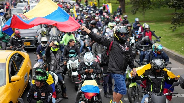 Motorcycle riders hold a caravan to protest the increase in...