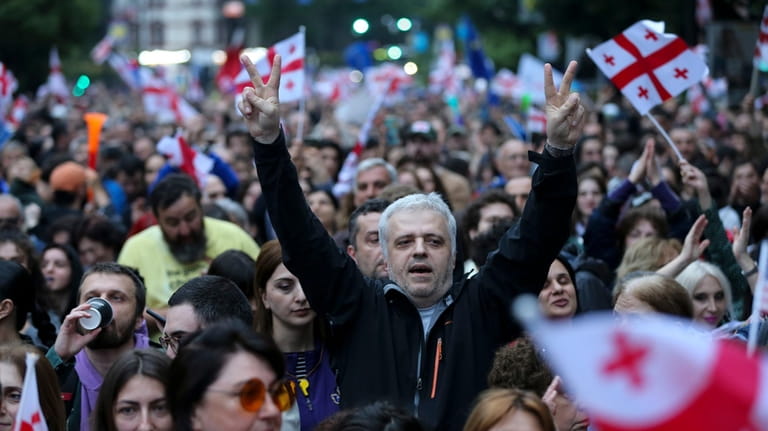 Demonstrators with Georgian national flags rally during an opposition protest...