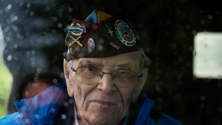 World War II veteran Kenneth Thayer sits in a jeep...