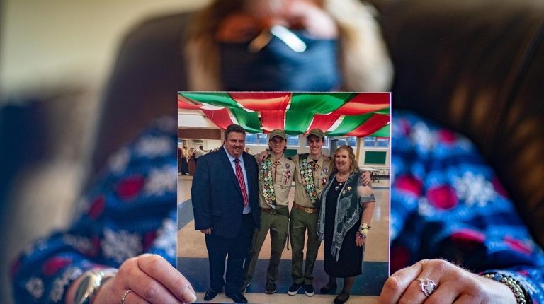 Venus Maziarz, of Mineola, holds a picture of her brother...