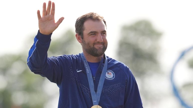 Scottie Scheffler, of the United States, waves to the crowd...