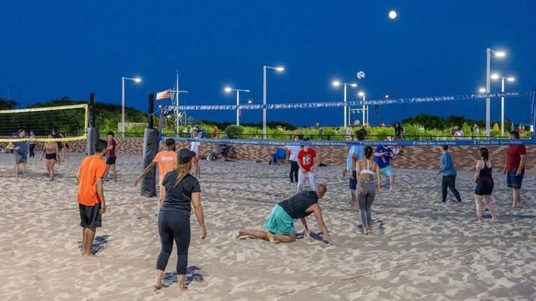 Teams play volleyball under the moon at Field 4 at...