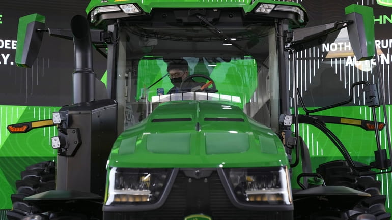 An attendee looks at a John Deere automated tractor at...