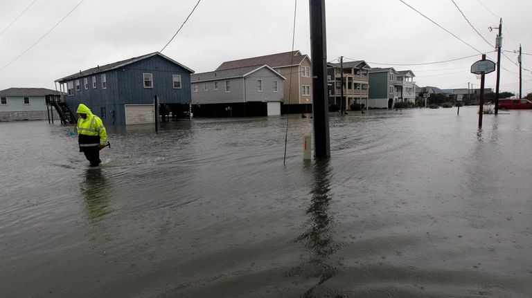 A Dare County utility worker checks on conditions along a...