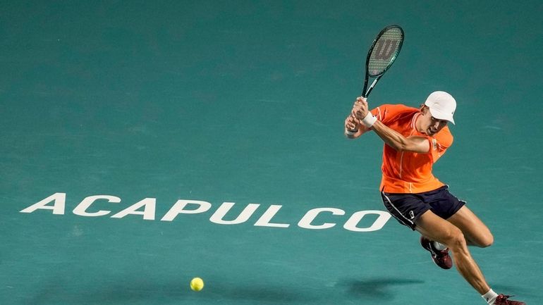 Alex de Minaur of Australia plays a backhand return to...