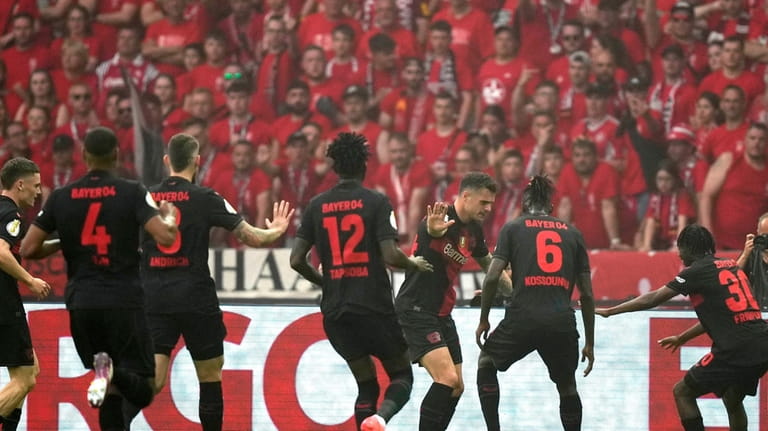 Leverkusen's Granit Xhaka, center, celebrates with team mates after scoring...