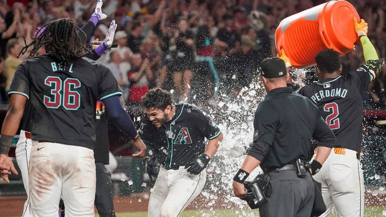 Arizona Diamondbacks' Adrian Del Castillo, middle, has ice dumped on...