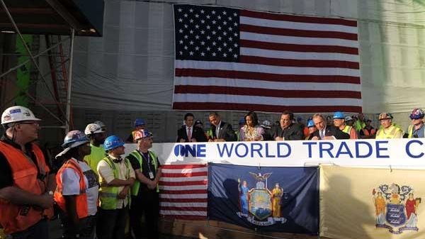 resident Barack Obama (2nd-L) signs a steel beam