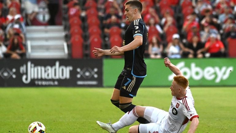 Toronto FC midfielder Matty Longstaff, right, tackles Philadelphia Union attacker...