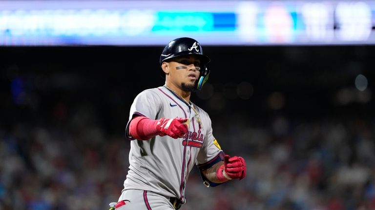 Atlanta Braves' Orlando Arcia reacts after hitting a home run...