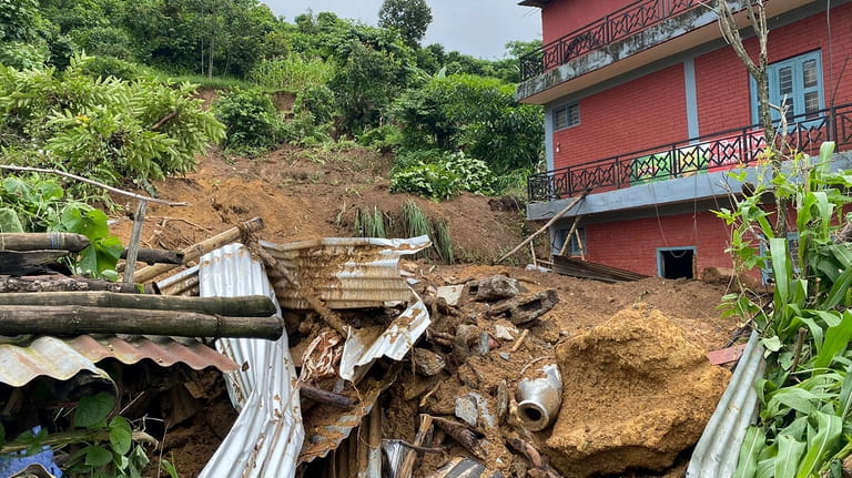 Damaged houses knocked by landslides are seen on the outskirts...