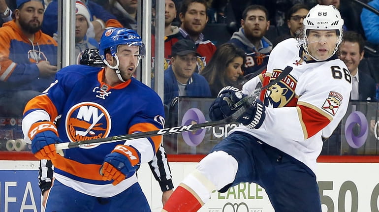 Alan Quine #10 of the New York Islanders collides with...