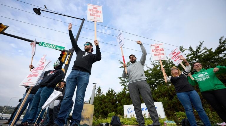 Boeing Machinists Union members and supporters wave to traffic on...