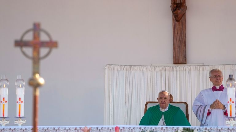 Pope Francis, flanked by Archbishop Diego Ravelli, right, presides over...