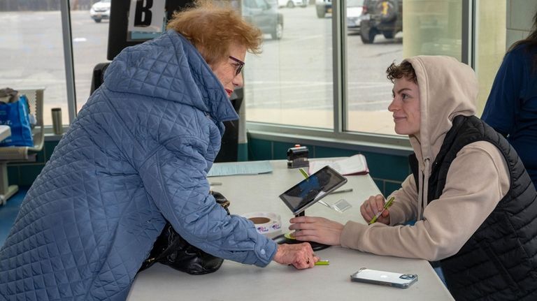 Flo McGuigan, left, of Hicksville votes early at the Town of Oyster...