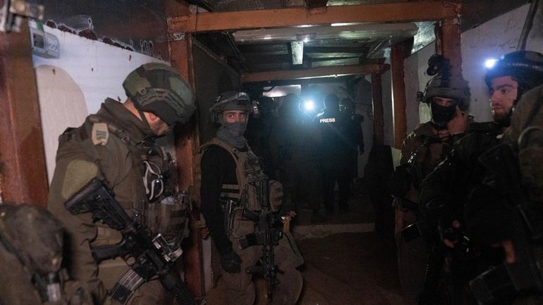 Israeli soldiers stan in a Hamas tunnel underneath a cemetery...