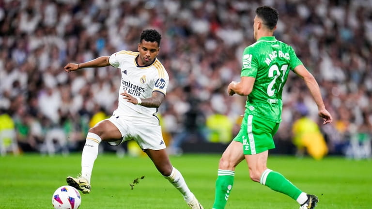 Real Madrid's Rodrygo, left, fights for the ball with Betis'...