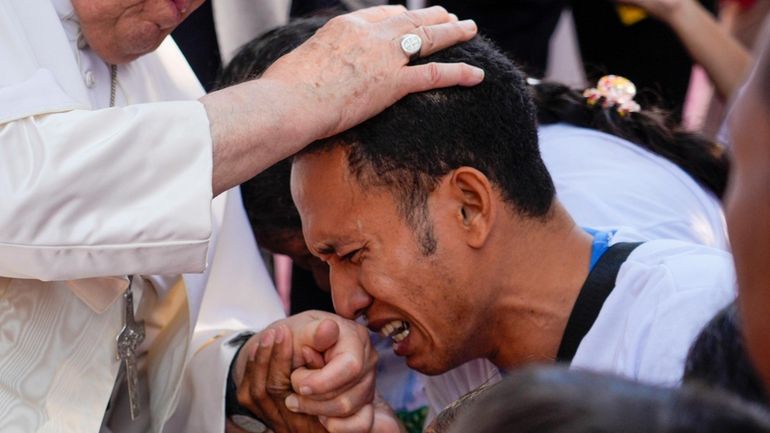 Pope Francis consoles a person during a visit at the...