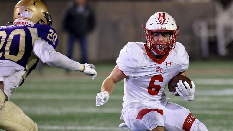 East Islip RB Andrew Cooper takes the handoff around the...