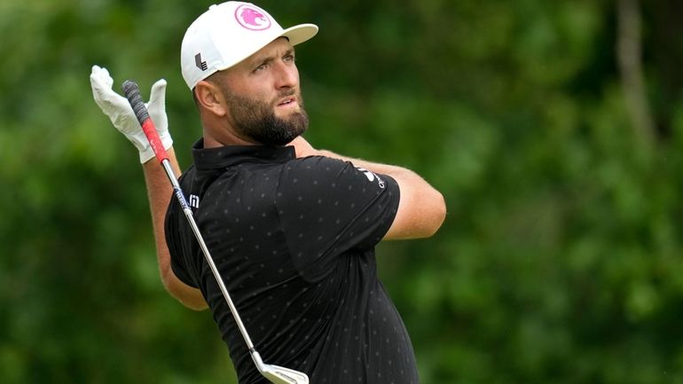 Jon Rahm, of Spain, reacts to his tee shot on...