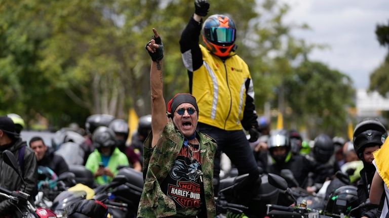 Motorcycle riders shout slogans against the government during a caravan...