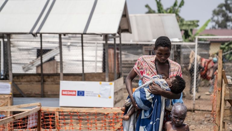 A woman walk away with her children suffering from mpox...