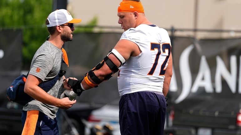 Denver Broncos offensive tackle Garett Bolles, right, is checked by...