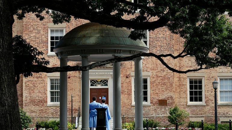 Graduates of the University of North Carolina take pictures at...