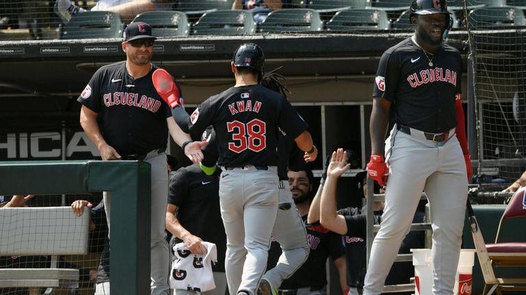 Cleveland Guardians manager Stephen Vogt, left, celebrates with Steven Kwan...