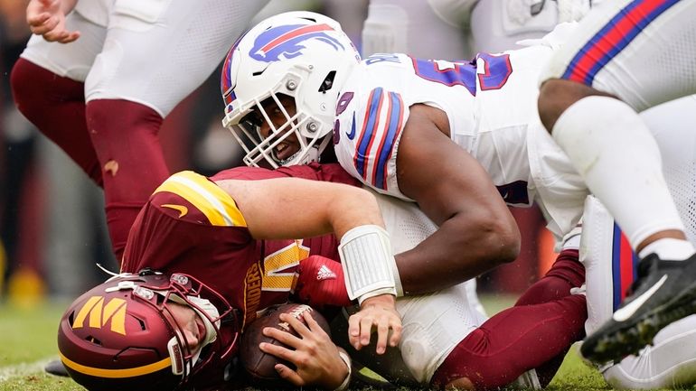 Washington Commanders quarterback Sam Howell (14) on the ground after...