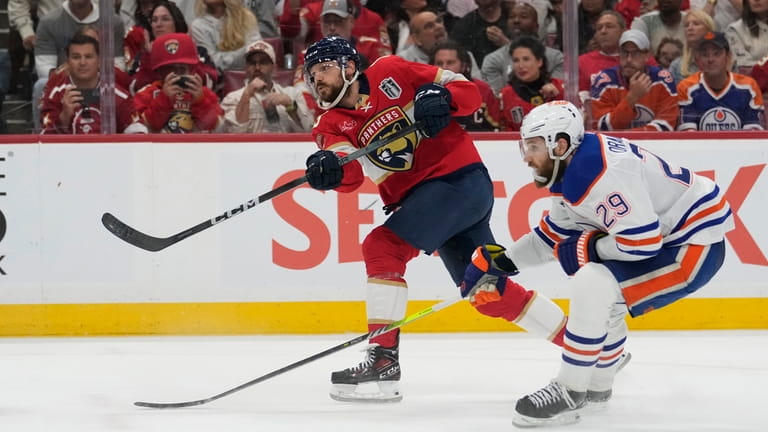 Florida Panthers center Sam Reinhart, left, aims the puck for...