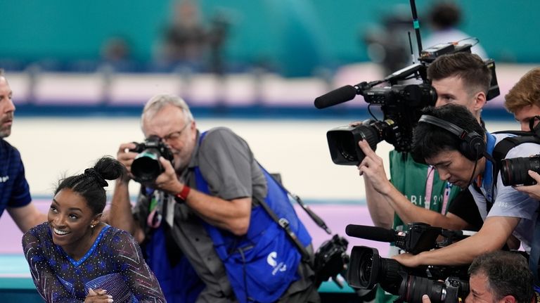 Simone Biles, of the United States, smiles after completing her...