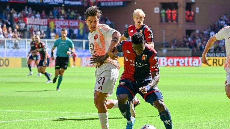 Genoa's Caleb Ekuban, left, and Roma's Paulo Dybala battle for...