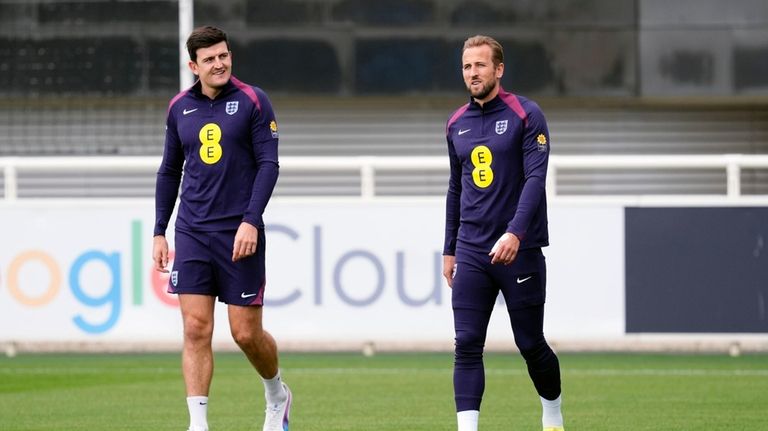 England's Harry Maguire, left, and Harry Kane, right, attend a...