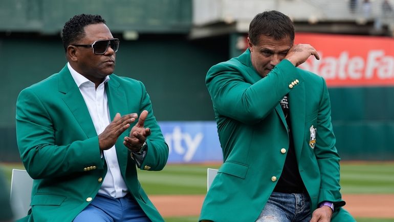 Former baseball player Jose Canseco, right, wipes away tears after...